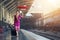 Traveler girl walking and waits train on railway platform