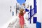 Traveler girl walks through the alleys in Mykonos picturesque town in Greece