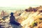 A traveler in a hat with a backpack stands on a mountain and looks at a beautiful view in Cappadocia in Turkey. Journey