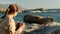 a traveler in a hat and shirt takes a photo of a sleeping seal