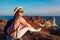 Traveler hiker woman relaxing on mountain top enjoying sea landscape on Santorini island. Summer vacation