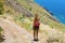 Traveler hiker woman walking along the pathway on Tenerife mountains. Natural tourism backpacker trekking adventure concept