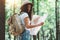 Traveler hipster woman with backpack and hat hold in hands location map and searching directional among trees in forest