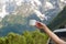 The traveler holds a cup of coffee in the mountains. White mug in the hands on the background of the mountains.