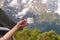 The traveler holds a cup of coffee in the mountains. White mug in the hands on the background of the mountains.