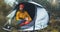 Traveler hugging red shiba inu in camp tent on background foggy rain forest, hiker woman with puppy dog in mist nature trip