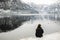 Traveler-Image. Traveler look at the mountain lake in winter. Travel and active life concept. Adventure and travel in the