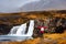 Traveler at Kirkjufellsfoss waterfall in Iceland