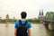 Traveler man enjoying his holiday in Europe. Rear view of male backpacker looking to Cologne City with Cathedral and Bridge