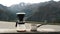 Traveler man making filter coffee and pours water in ground coffee beans against mountain view