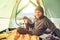 Traveler man meet morning in camping tent with cup of tea