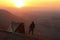 Traveler man in mountains with tent in early morning