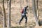 Traveler man walking in forest with poles