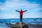 Traveler man wear red clothes and raising arm standing on mountain at daytime in Lake Baikal, Siberia, Russia