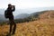 A traveler in the mountains looks in the binoculars