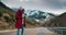 Traveler and professional photographer walks on empty mountain road shot picture