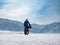 Traveler rides a fat bike on the ice of a frozen mountain lake