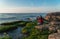 Traveler on a rocky seashore overgrown with green algae taking pictures