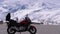 Traveler s motorcycle stands on a mountain pass amid the snowy Alps in Switzerland