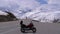 Traveler s motorcycle stands on a mountain pass amid the snowy alps in Switzerland