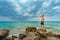 Traveler shirtless standing on the rocks near the sea looking far away at horizon