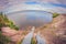 Traveler sitting on a high cliff on the lake, first-person view, fisheye distortion