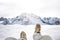 Traveler sitting on mountain peak, POV view on great winter mountains above the cloud and hiking boots