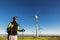 Traveler standing in field with windmills on sunny day