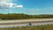 Traveler standing on a motorcycle on highway, takes off a drone near wind farms. Austria