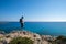 Traveler standing on a rocky seashore of the Mediterranean sea a