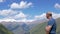 A traveler stands high in the mountains and looks at the top of Elbrus