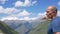 A traveler stands high in the mountains and looks at the top of Elbrus