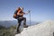 A traveler stands on top of a mountain and looks out to sea.