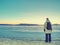 Traveler stay on ice of frozen sea. Woman with backpack