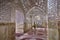 Traveler strolls inside mirror mosque, Yazd, Iran.