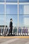 Traveler with suitcase next to row of luggage carts at airport