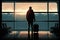 A traveler with a suitcase standing and waiting in an airport terminal before departure, back view.