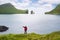 Traveler takes selfie on background of Drangarnir and Tindholmur, Faroe Islands