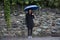 Traveler thai women holding umbrella and walking on the road at raining time