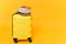 Traveler tourist suitcase trunk luggage bag with summer hat and passport isolated on yellow orange background. Passenger