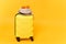 Traveler tourist suitcase trunk luggage bag with summer hat, sunglasses isolated on yellow orange background. Passenger