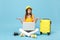 Traveler tourist woman in yellow casual clothes, hat with suitcase laptop pc photo camera  on blue background