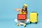 Traveler tourist woman in yellow casual clothes, hat with suitcase laptop pc photo camera isolated on blue background