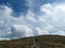 Traveler on trail in mountains with great cloudscape