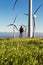 Traveler with trekking poles in meadow with windmills