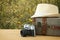 traveler vintage luggage, camera and fedora hat over wooden table infront of a field at sunset light.