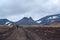 Traveler walking through the desert volcanic terrain, the foot of the mountains, volcanic