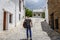 A traveler walks along a quiet street, in a village of La Alpujarra, Spain