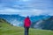 Traveler walks through the alpine meadow to the cliff