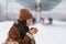 Traveler woman drinking hot tea travelling during cold winter waiting for train at outdoor platform